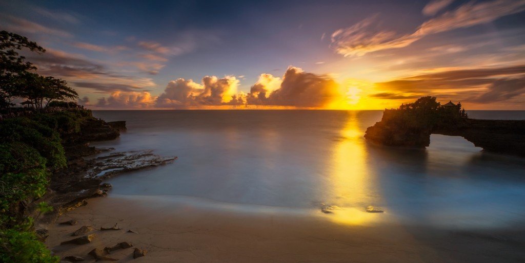 Batu Bolong temple in tanah lot temple area at stunning sunset view, Bali island, Indonesia - Mari Bali Tours 